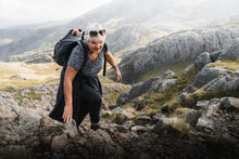 Load image into Gallery viewer, Lady scrambling up some rocks
